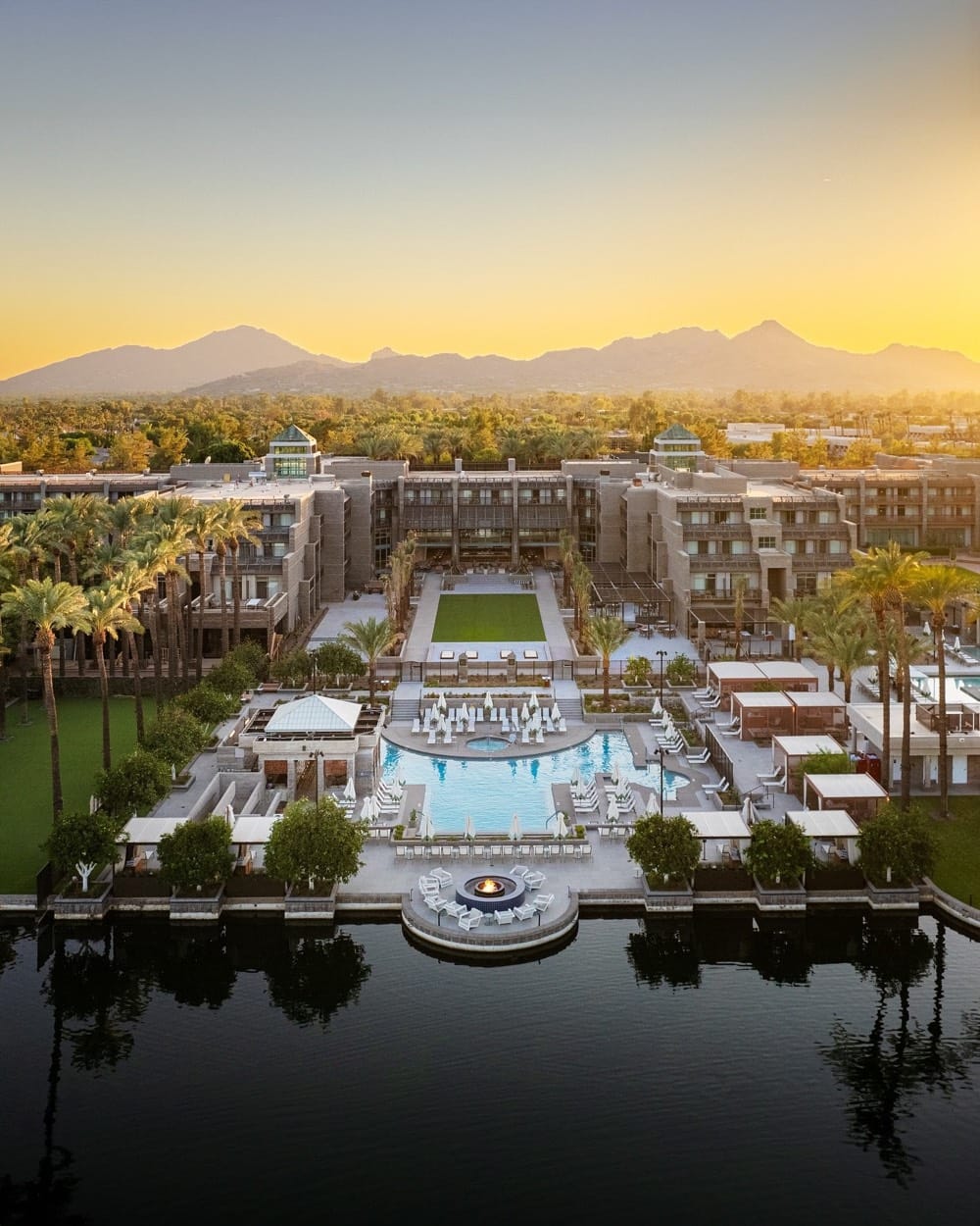 Grand Hyatt Scottsdale from above at sunset, the pools and lake in front, mountains behind