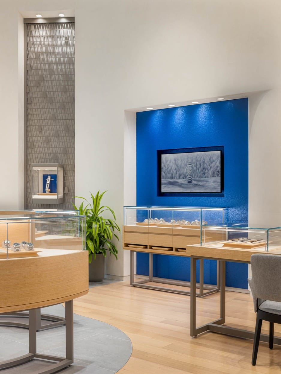 Grand Seiko boutique corner, watch cases below a framed photo on a blue wall
