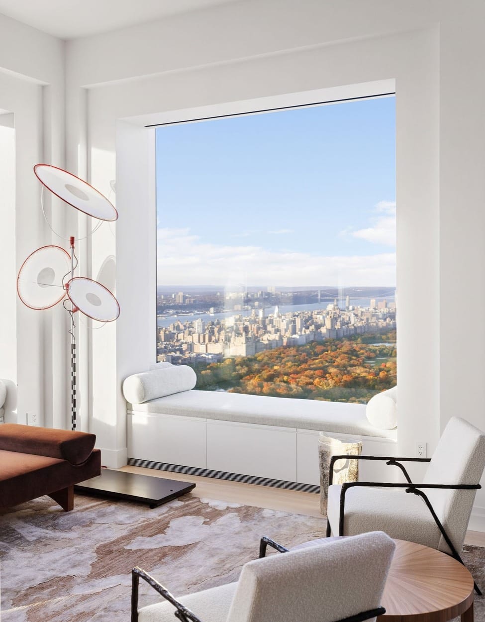 Living room with a window seat framing Central Park in fall and the city skyline