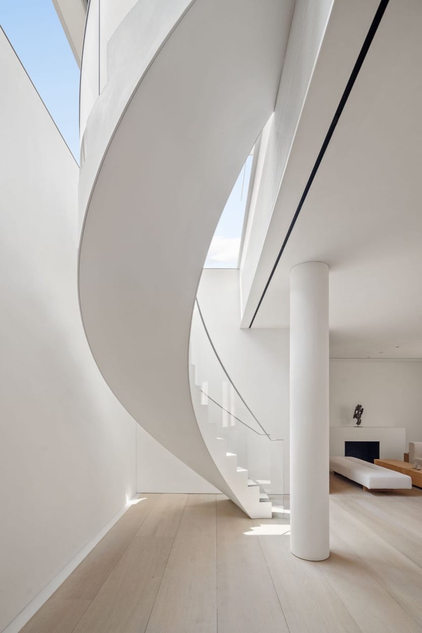 White spiral staircase in a minimalist home, pale oak floors