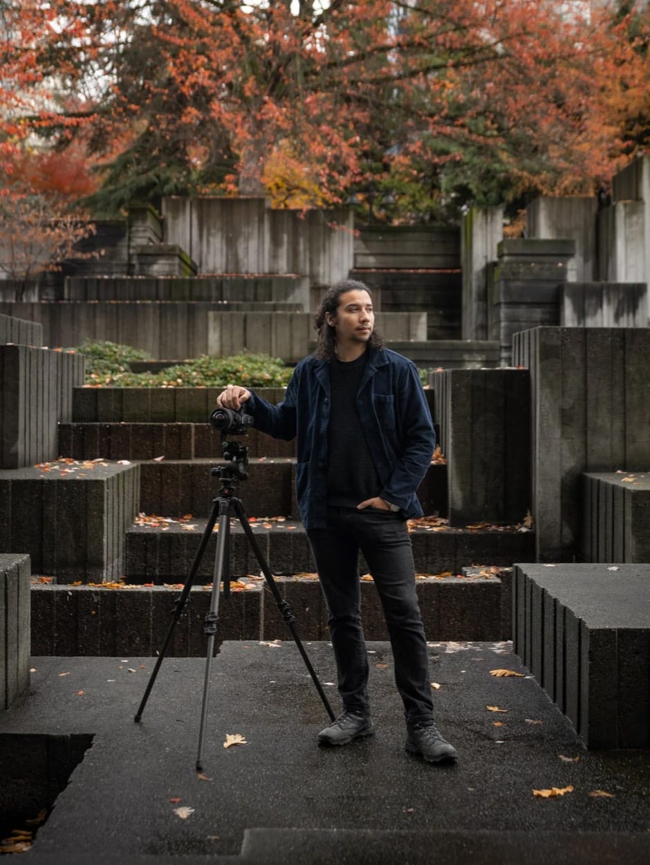 Santiago León, Seattle photographer, with his camera on a tripod among concrete terraces and fall leaves